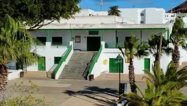 Escalinata del Teleclub con barandillas verdes y la galería porticada del primer piso